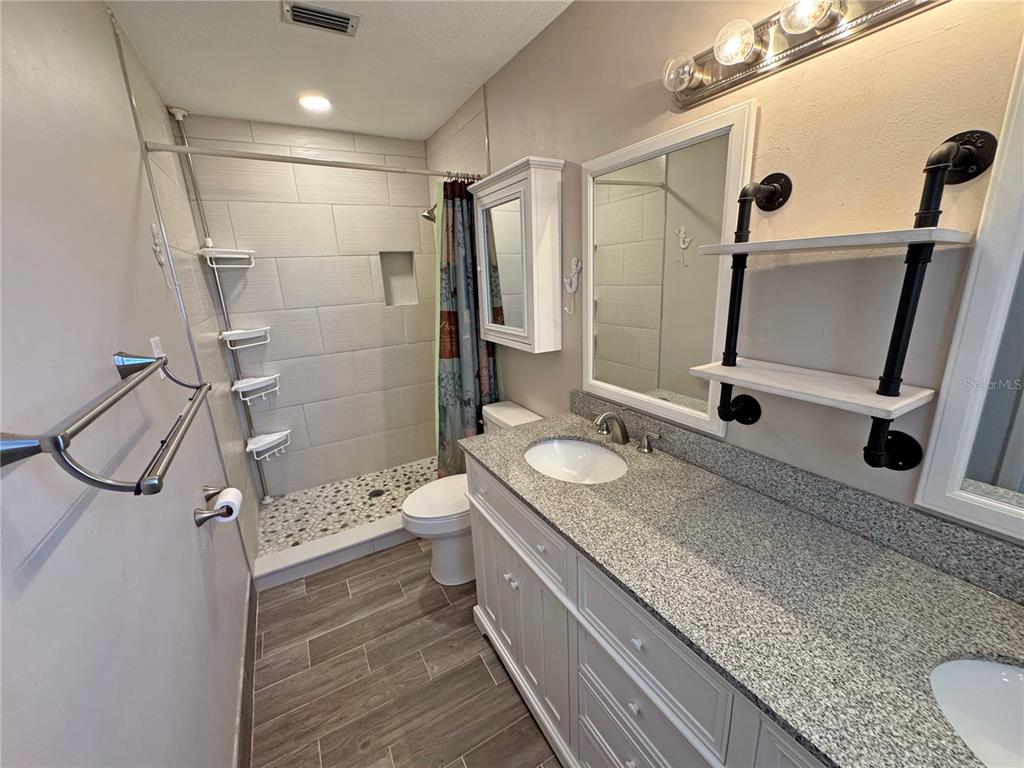1421 Suwanee Road Daytona Beach, FL 32114 - Photo 14 of 21 a bathroom with a granite countertop sink toilet and shower