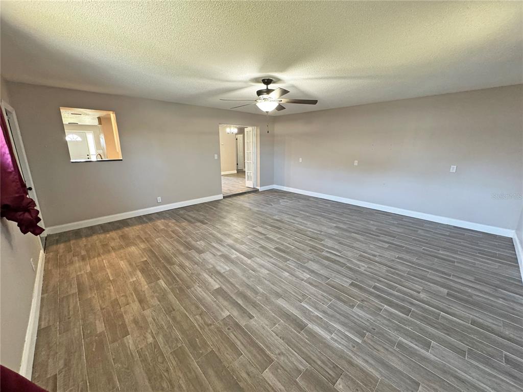 1421 Suwanee Road Daytona Beach, FL 32114 - Photo 10 of 21 wooden floor in an empty room with a window