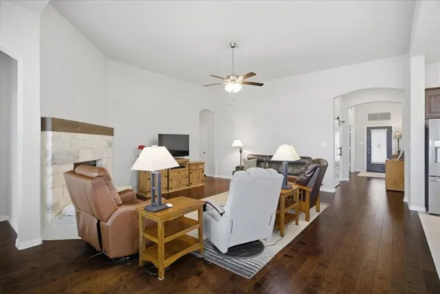 a living room with furniture a flat screen tv and a fireplace