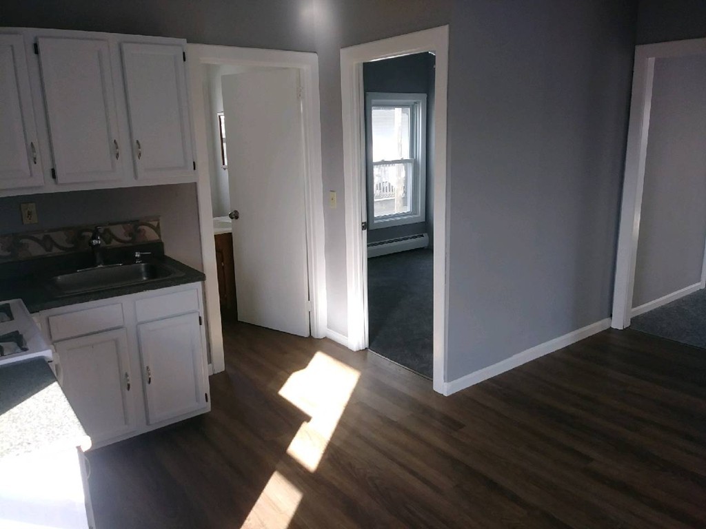 141 Grant Street Fall River, MA 02721 - Photo 6 of 19 a kitchen with a refrigerator and white cabinets
