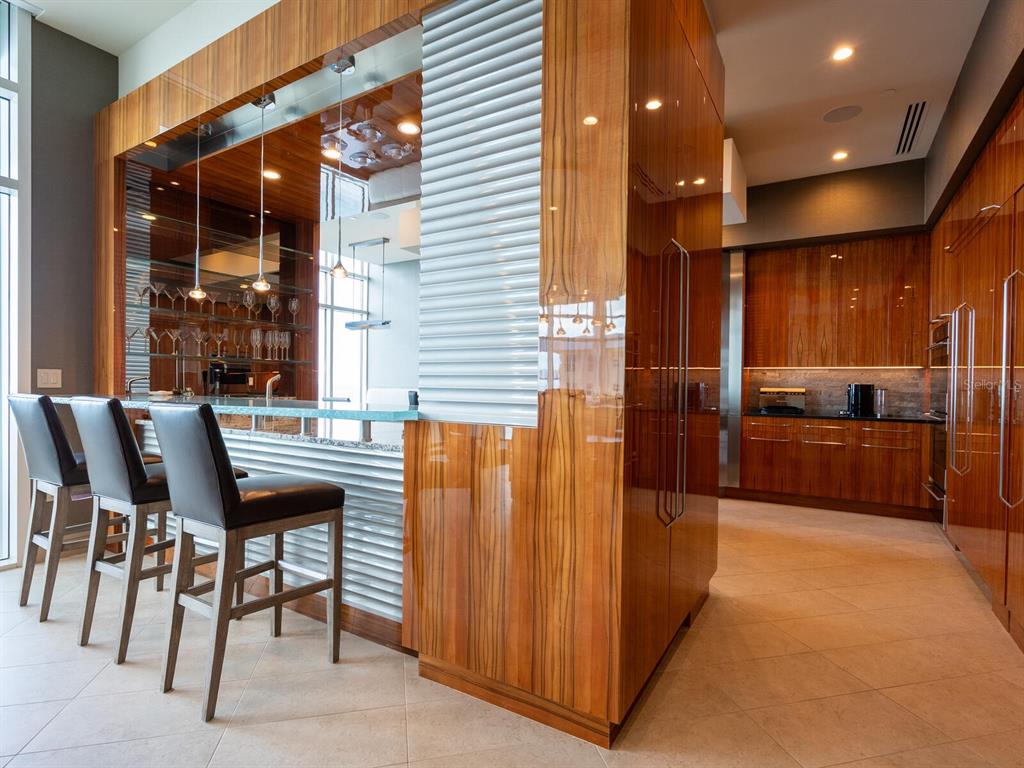 655 Longboat Club Road, Unit 1PH Longboat Key, FL 34228 - Photo 21 of 53 a kitchen with a table chairs refrigerator and chairs