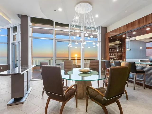 a view of a dining room with furniture a chandelier and wooden floor