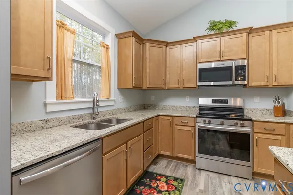a kitchen with granite countertop a stove a sink and a microwave