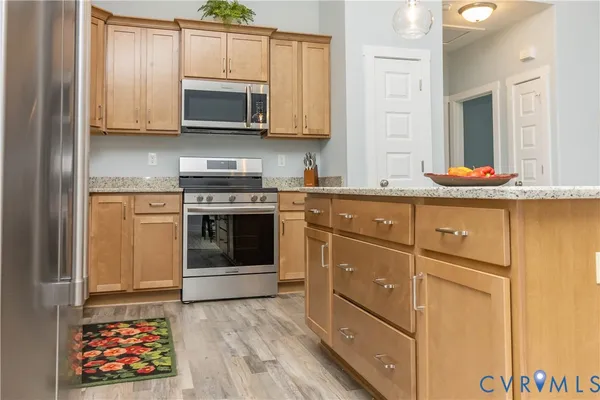 a kitchen with stainless steel appliances granite countertop a stove and a microwave