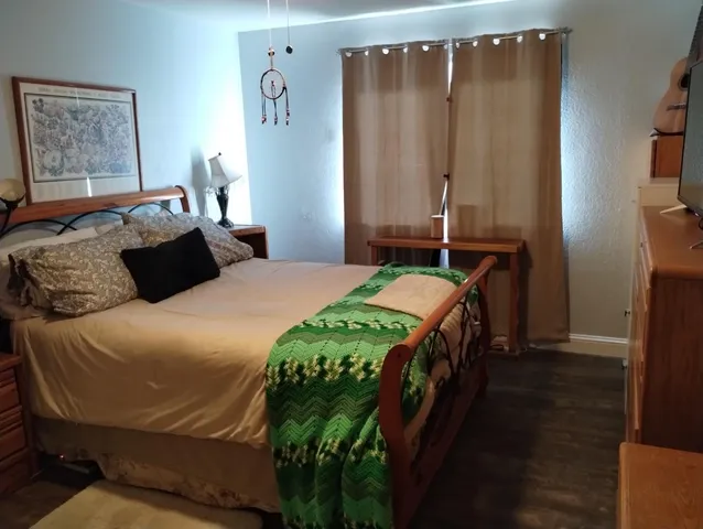 a bedroom with a bed next to a window