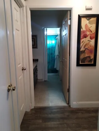 a view of a hallway with wooden floor and closet