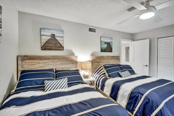 a bedroom with two beds and a night stand