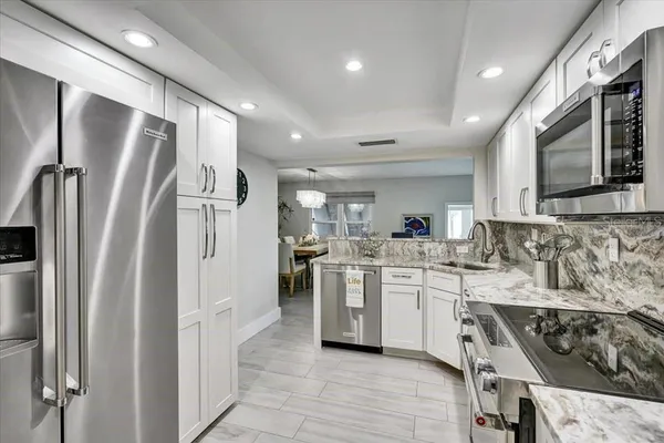 a kitchen with white cabinets and stainless steel appliances