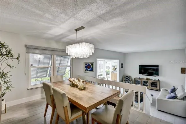 a view of a dining room with furniture a chandelier and wooden floor
