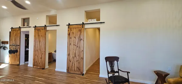 a view of a hallway with wooden floor and chair