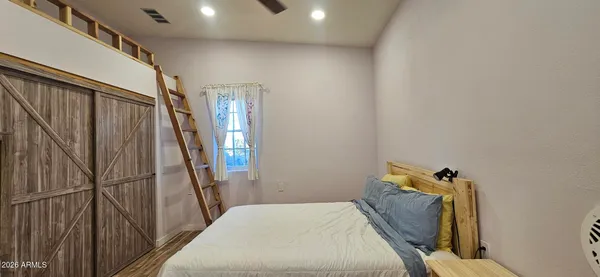 a bedroom with a bed and wooden floor
