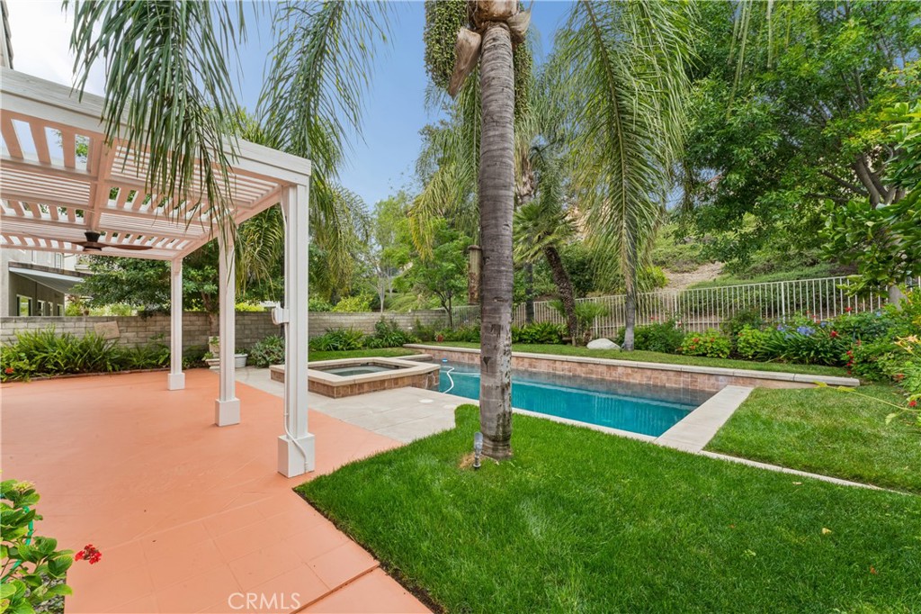 26023 Salinger Lane Stevenson Ranch, CA 91381 - Photo 27 of 35 Stunning backyard retreat complete with a sparkling pool, relaxing spa, lush palm trees, and fruit trees.