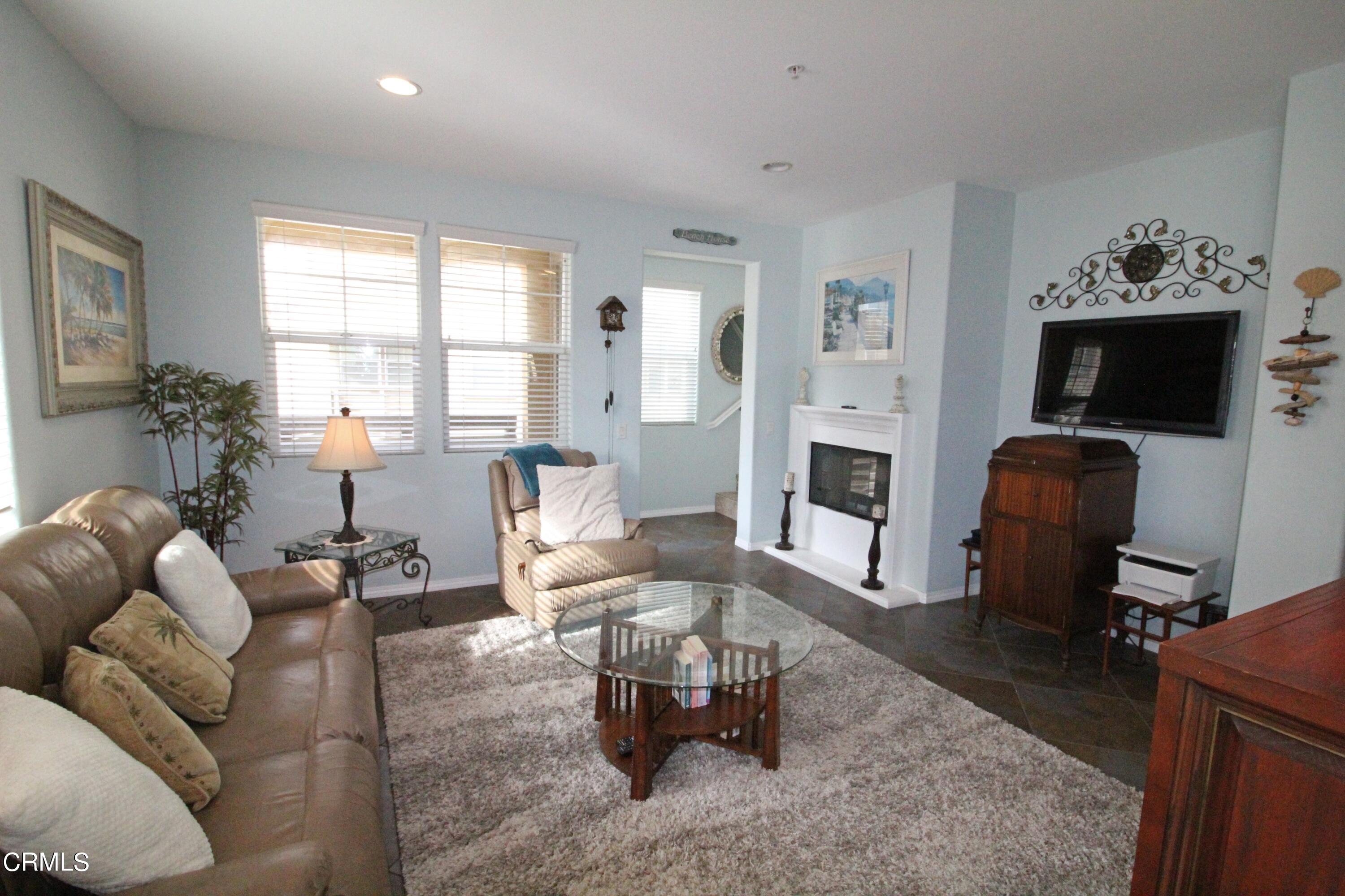 1428 Windshore Way Oxnard, CA 93035 - Photo 7 of 29 a living room with furniture a fireplace and a flat screen tv