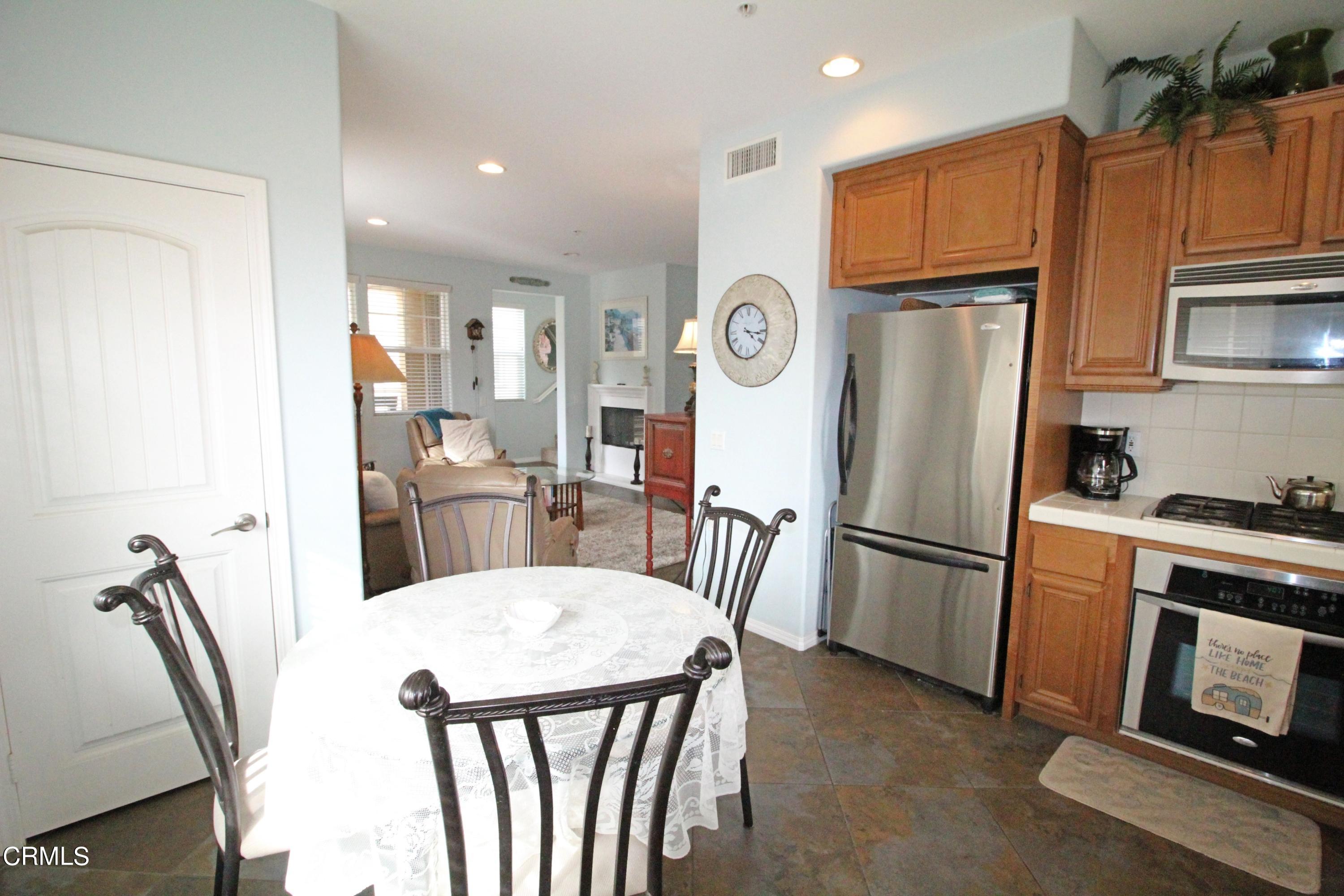 1428 Windshore Way Oxnard, CA 93035 - Photo 8 of 29 a kitchen with stainless steel appliances a refrigerator a stove a dining table and chairs