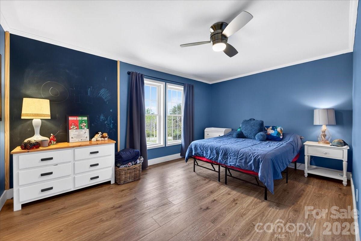 4624 South Olivers Cross Road Maiden, NC 28650 - Photo 25 of 48 a spacious bedroom with a bed and a chandelier