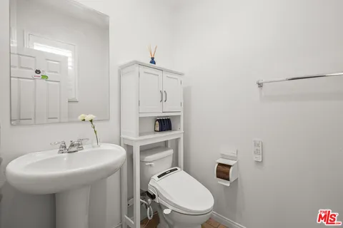 a bathroom with a toilet sink and mirror