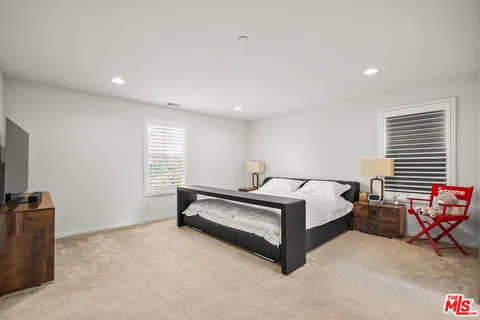 a spacious bedroom with a bed and a tv in it