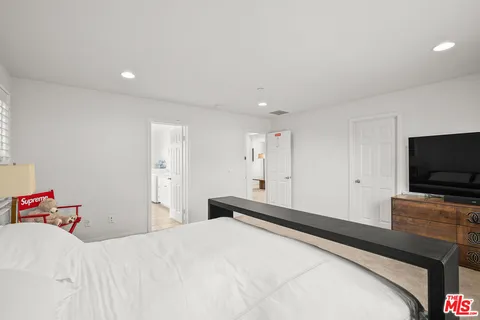 a bedroom with a bed and a flat screen tv