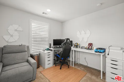 a view of a workspace with furniture and a window