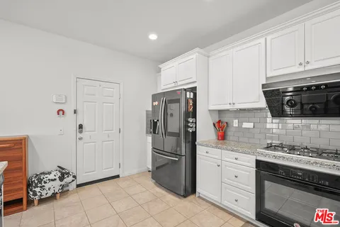 a kitchen with stainless steel appliances granite countertop a refrigerator and a stove top oven