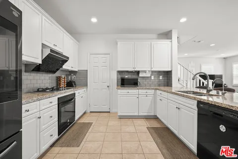 a kitchen with stainless steel appliances kitchen island granite countertop a sink and cabinets