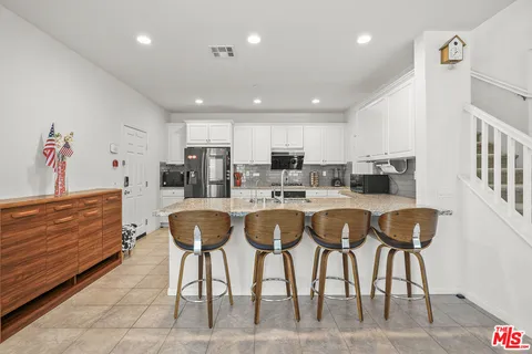 a living room with kitchen island furniture and a kitchen view