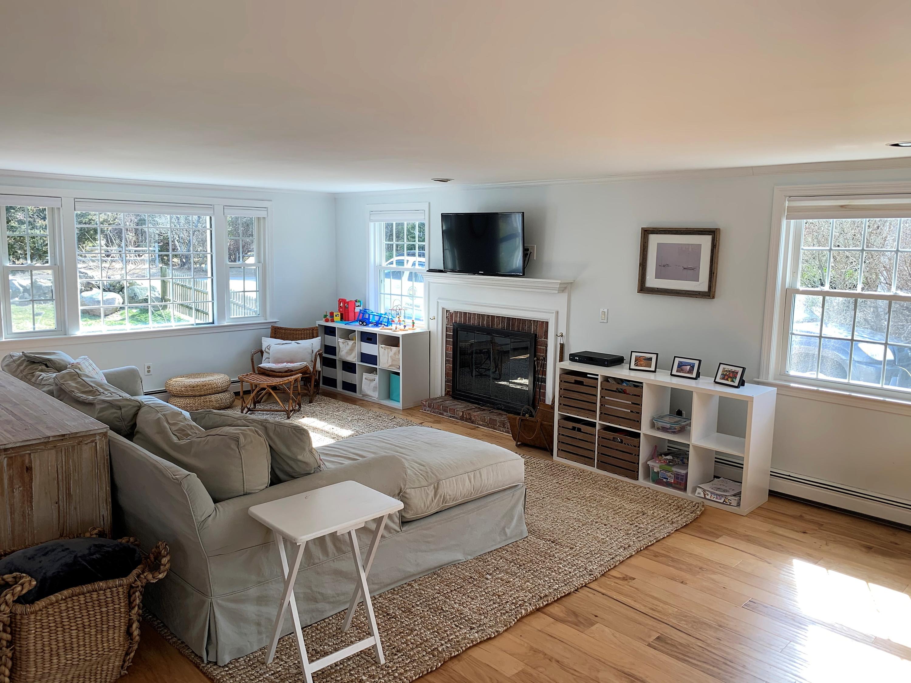84 Nauset Heights Road Orleans, MA 02653 - Photo 12 of 24 a living room with furniture a flat screen tv and a fireplace