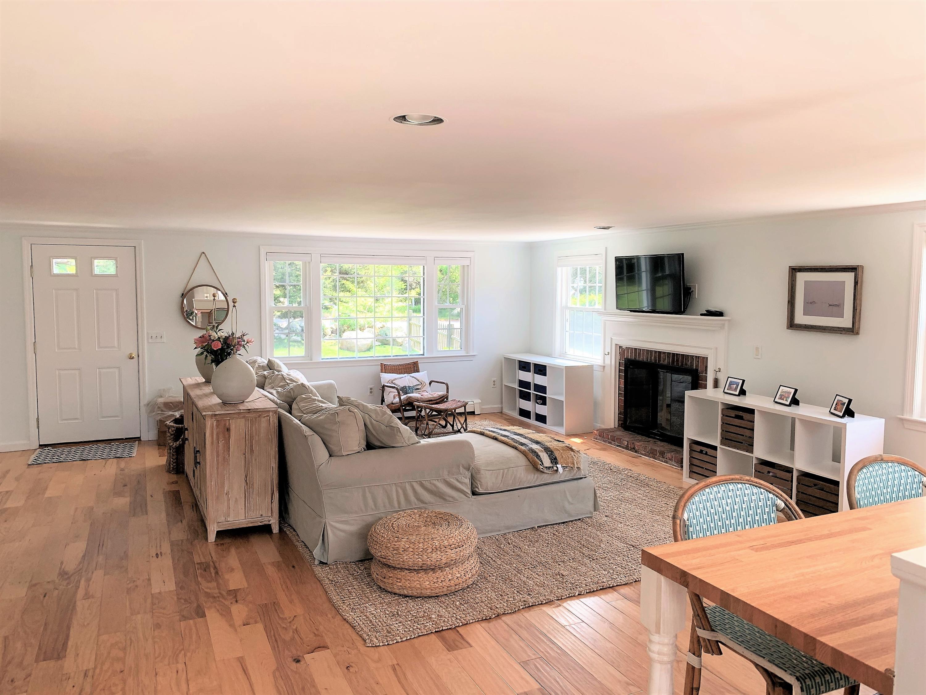 84 Nauset Heights Road Orleans, MA 02653 - Photo 7 of 24 a living room with furniture a fireplace and a large window