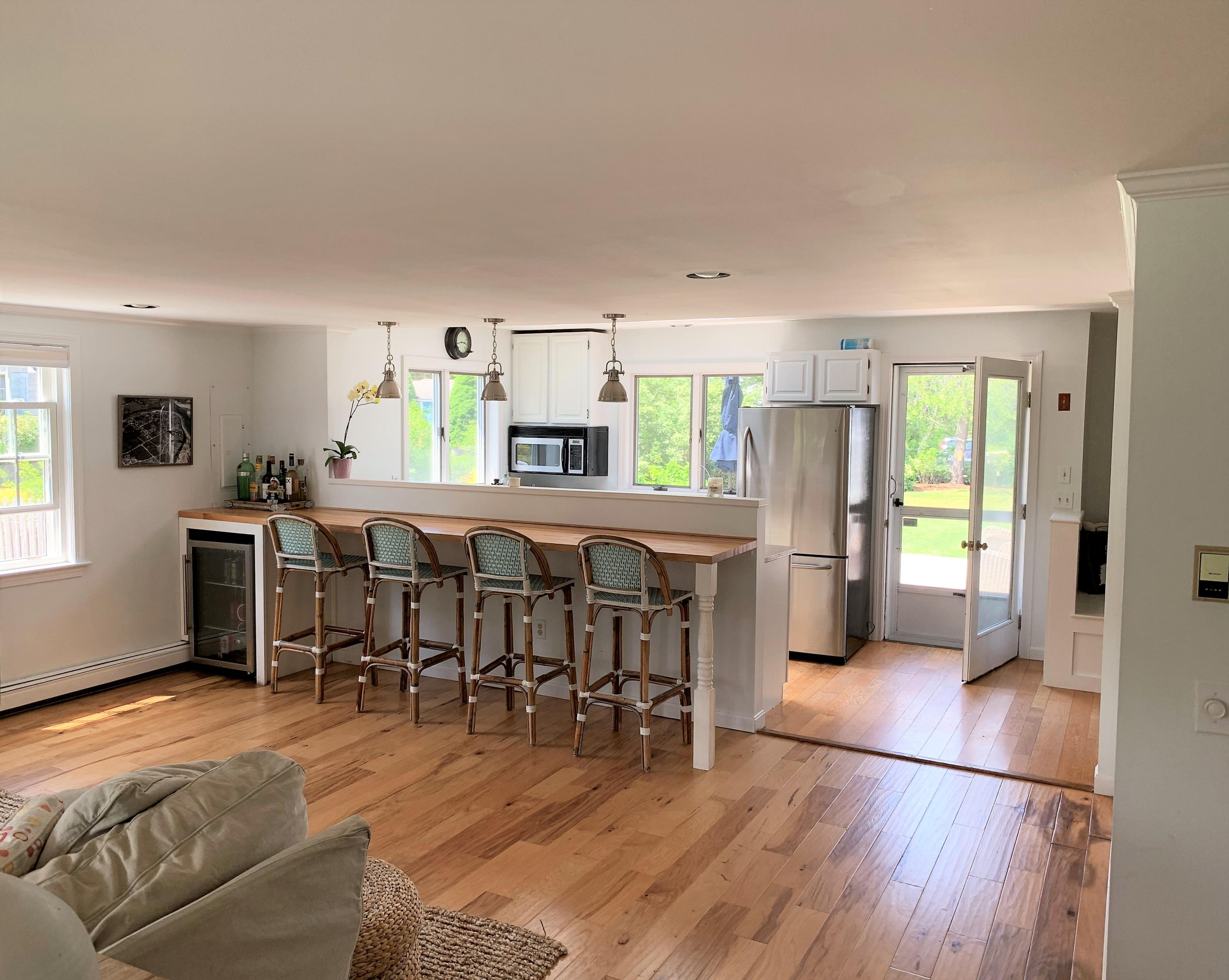 84 Nauset Heights Road Orleans, MA 02653 - Photo 8 of 24 a dining hall with stainless steel appliances a dining table wooden floor and a large window