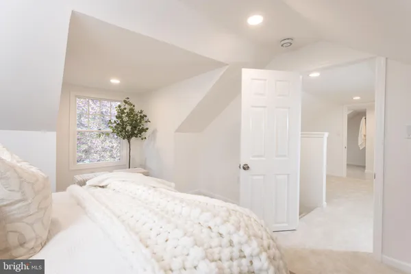 a large bedroom with a bed and a large mirror