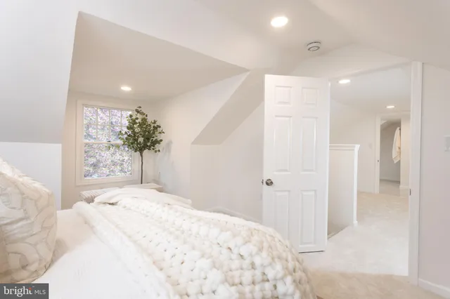 a large bedroom with a bed and a large mirror