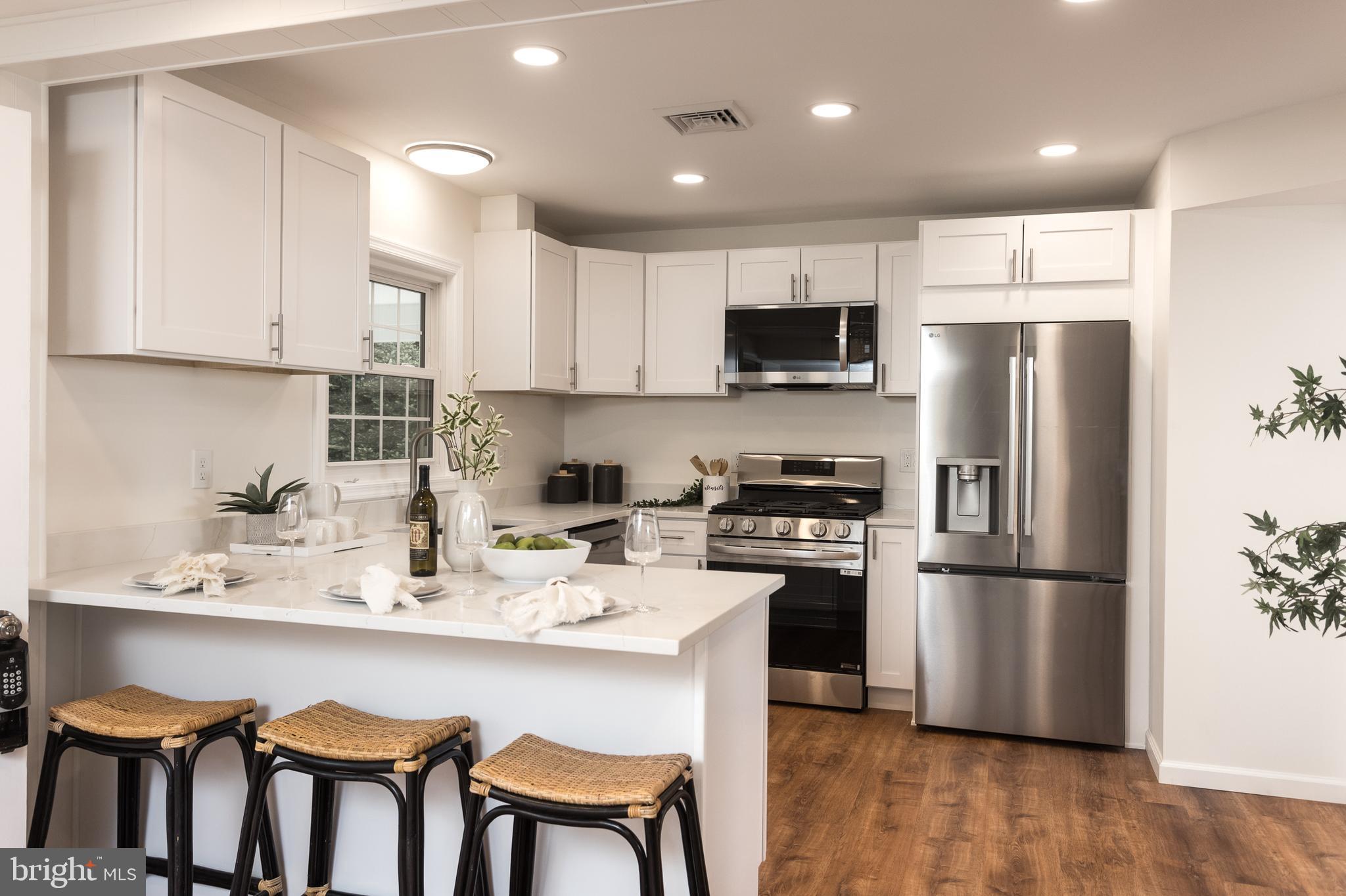 16742 Ridge Road Upperco, MD 21155 - Photo 7 of 38 a kitchen with stainless steel appliances granite countertop a refrigerator a stove a sink a dining table and chairs