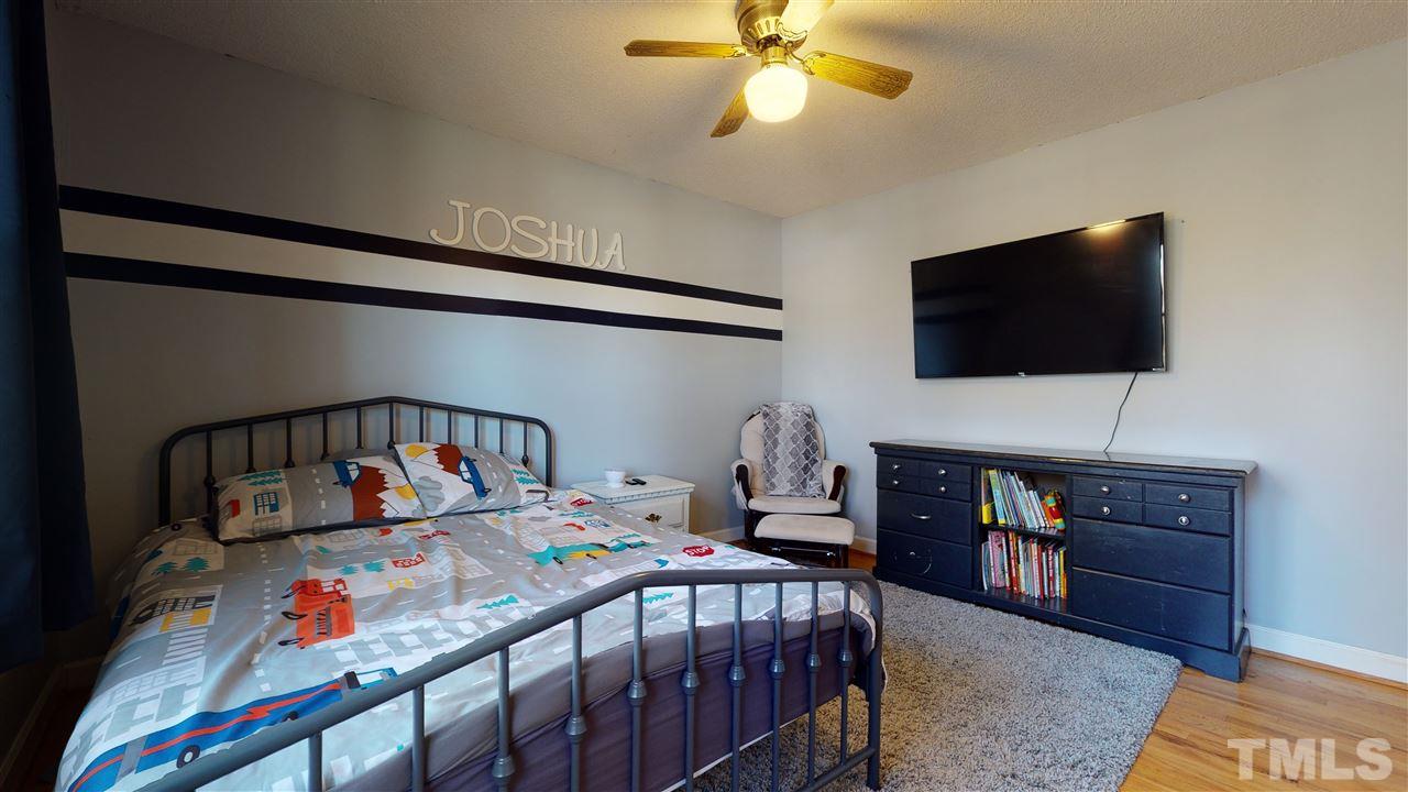 5904 Timber Ridge Drive Raleigh, NC 27609 - Photo 21 of 30 a bedroom with a bed window and a flat screen tv