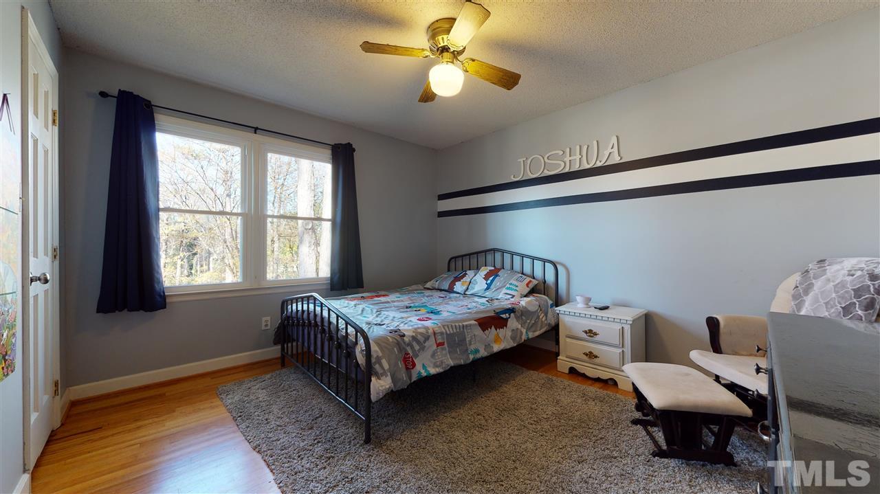 5904 Timber Ridge Drive Raleigh, NC 27609 - Photo 22 of 30 a bedroom with a bed and a chandelier