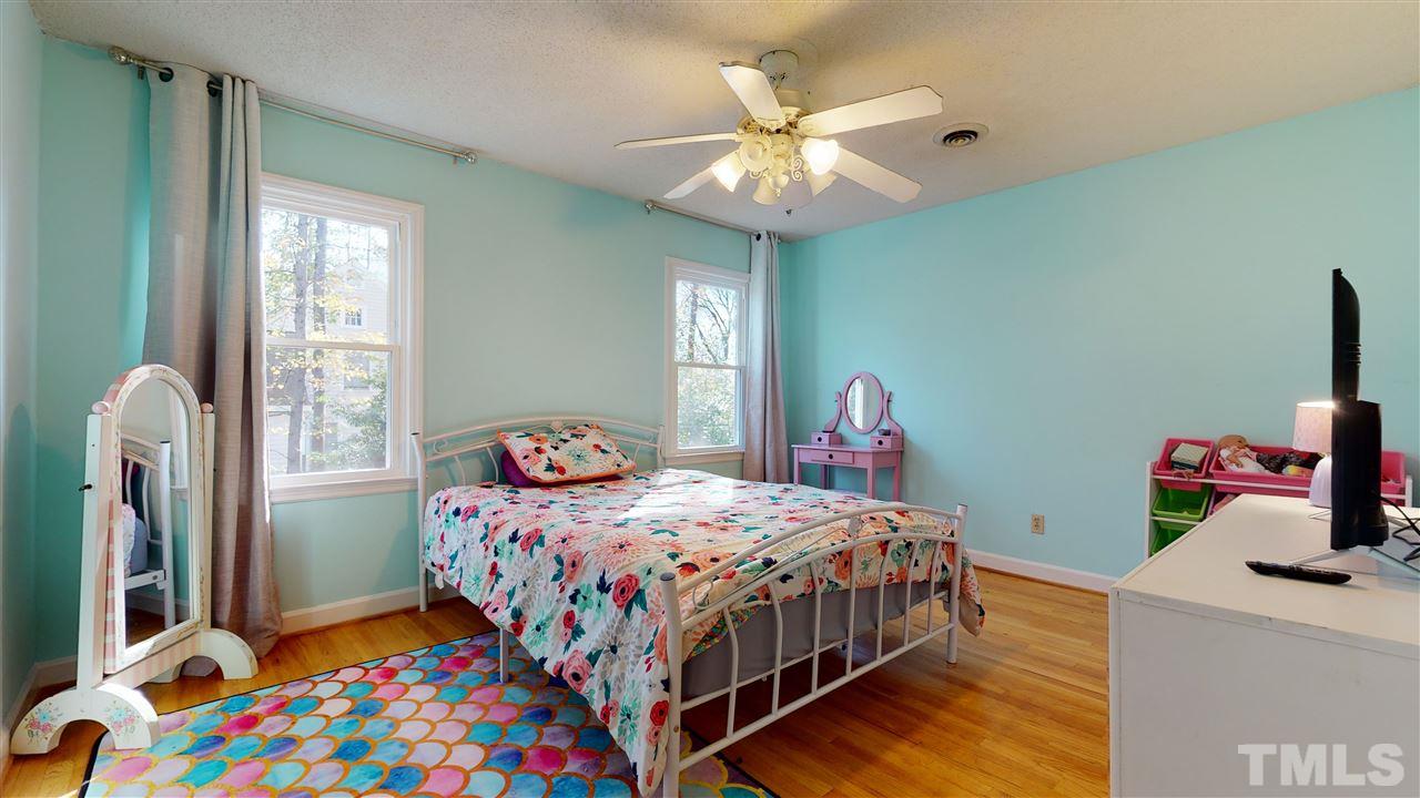 5904 Timber Ridge Drive Raleigh, NC 27609 - Photo 25 of 30 a bedroom with a bed and a chandelier