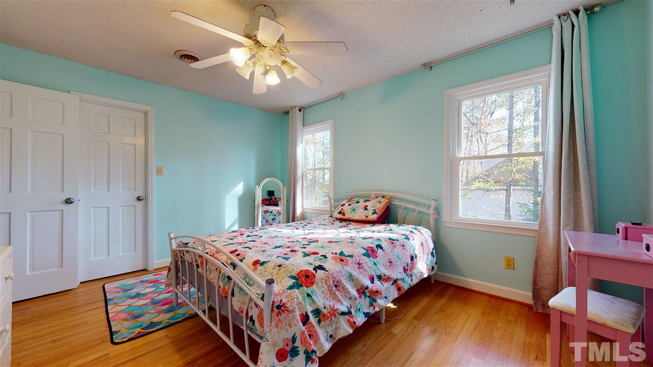5904 Timber Ridge Drive Raleigh, NC 27609 - Photo 26 of 30 a bedroom with a bed and a chandelier