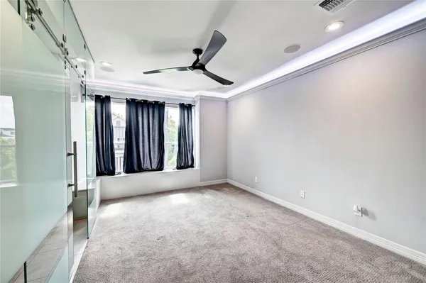 a view of an empty room with window and cabinet