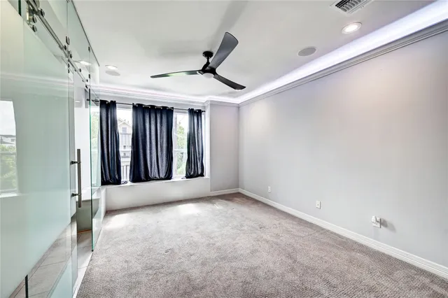 a view of an empty room with window and cabinet