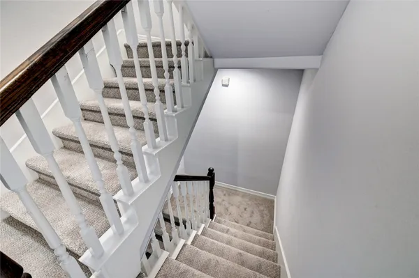 a view of staircase with wooden floor and white walls