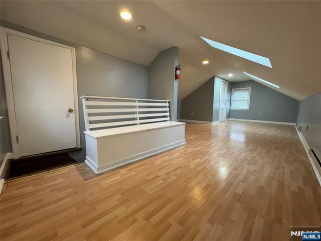 a view of a hallway with stairs and a room with wooden floor