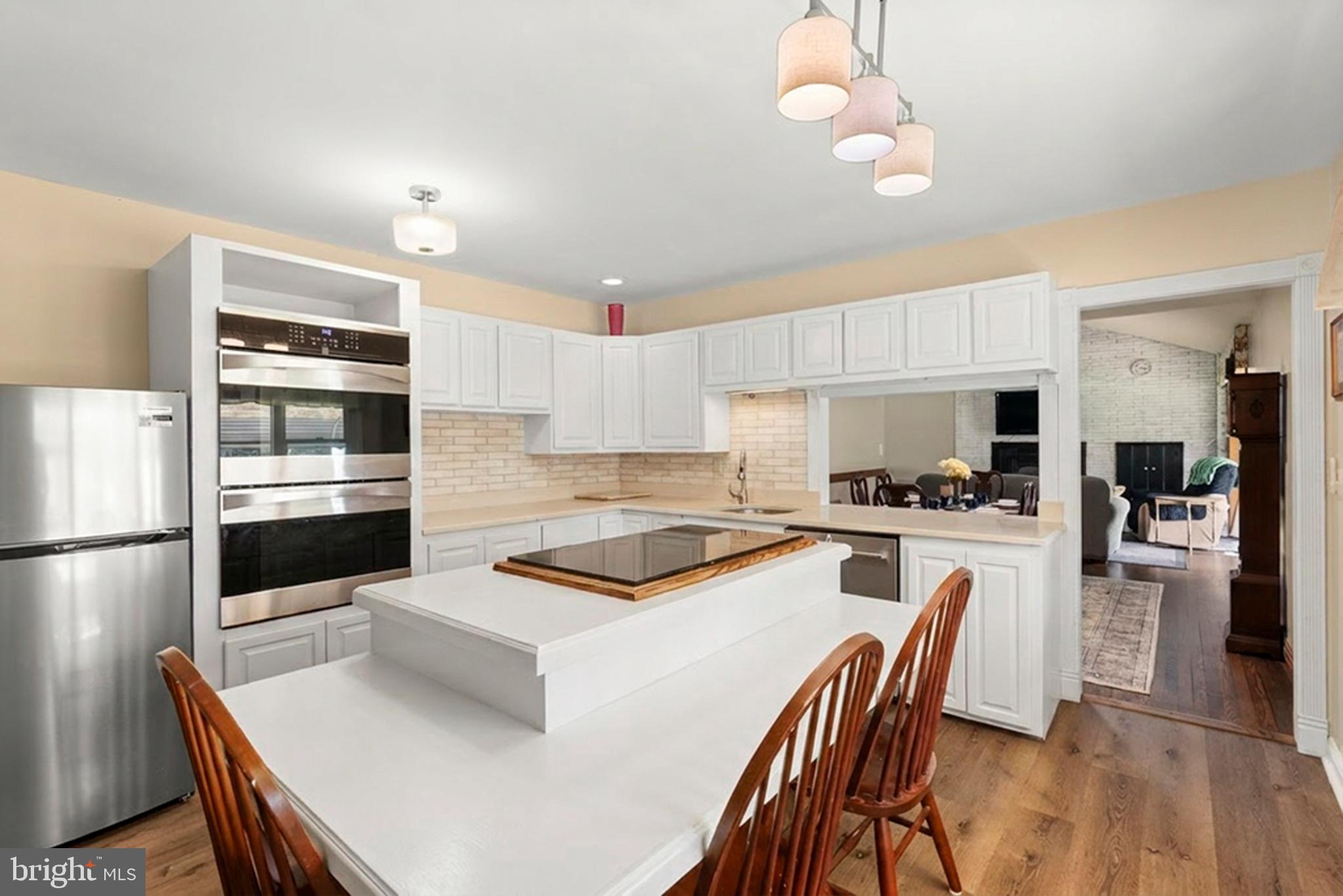 6605 Mt Vista Road Kingsville, MD 21087 - Photo 50 of 54 a kitchen with a refrigerator a stove a dining table and chairs with wooden floor