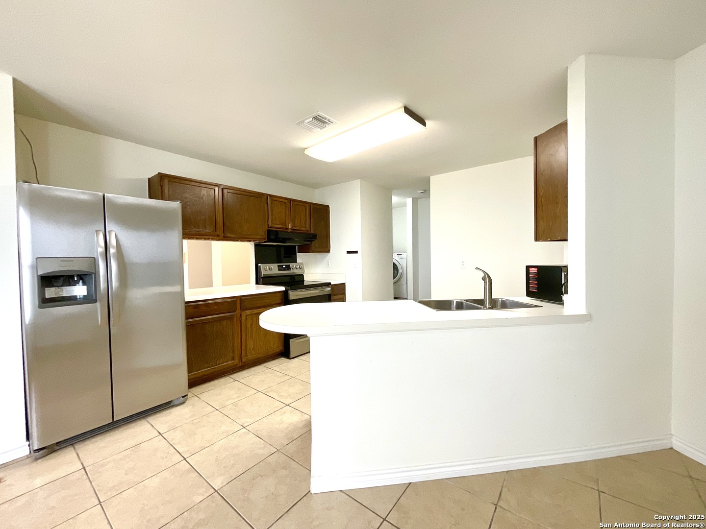 9919 Fortune Ridge Drive Converse, TX 78109 - Photo 12 of 34 a kitchen with stainless steel appliances a refrigerator sink and microwave