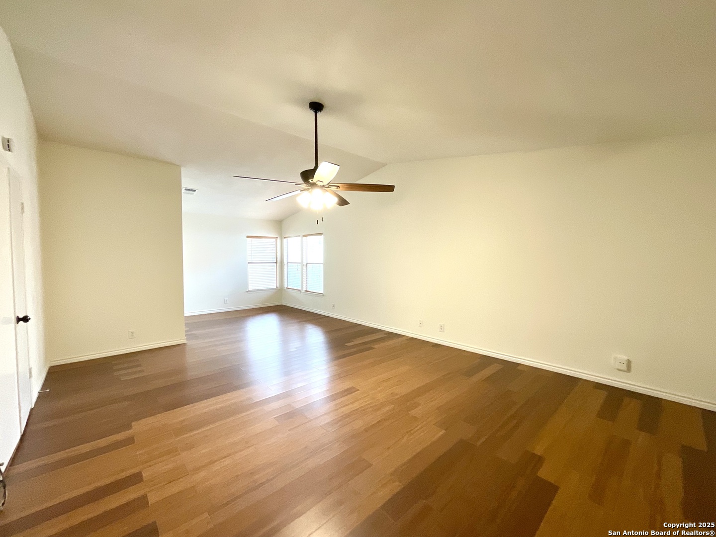 9919 Fortune Ridge Drive Converse, TX 78109 - Photo 21 of 34 a view of a room with wooden floor and a ceiling fan