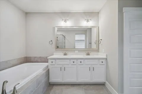a bathroom with a granite countertop bathtub a sink and a mirror