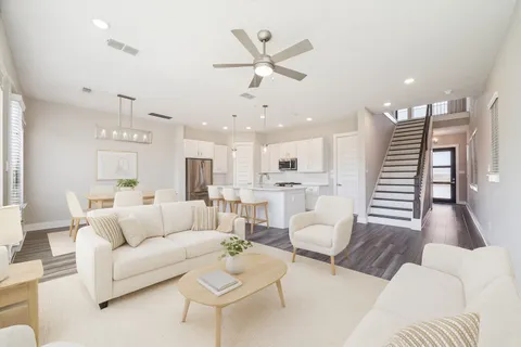 a living room with furniture and a view of kitchen