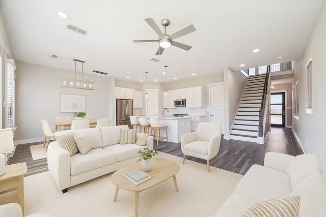 a living room with furniture and a view of kitchen
