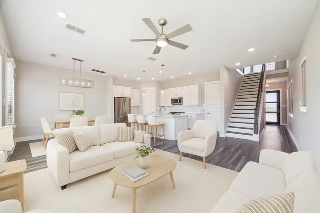 a living room with furniture and a view of kitchen