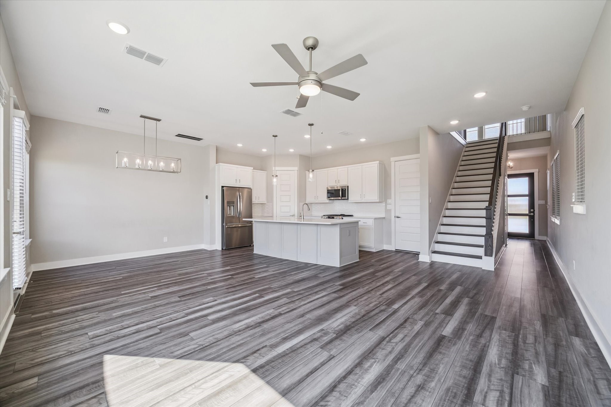 10961 Hewitt Cliff Lane Houston, TX 77043 - Photo 5 of 26 a view of an empty room with wooden floor and a ceiling fan