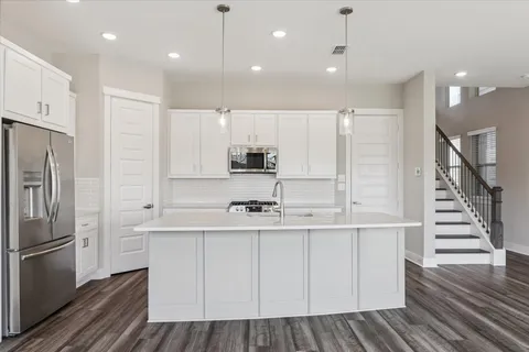 a kitchen with kitchen island white cabinets and stainless steel appliances