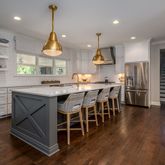 a kitchen with stainless steel appliances kitchen island granite countertop a stove a refrigerator and a dining table with wooden floor